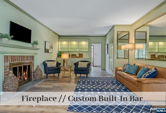 living area featuring a brick fireplace, wood finished floors, and ornamental molding