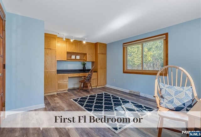 interior space with visible vents, rail lighting, baseboards, dark wood-style flooring, and built in study area