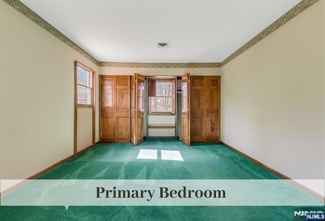 carpeted spare room with visible vents and baseboards