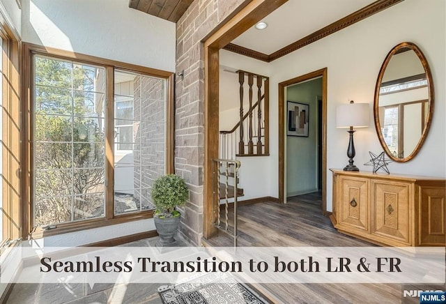 entryway with baseboards, a healthy amount of sunlight, wood finished floors, and crown molding