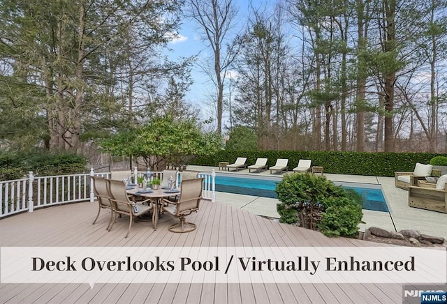 view of swimming pool featuring outdoor dining space, a fenced in pool, and a wooden deck