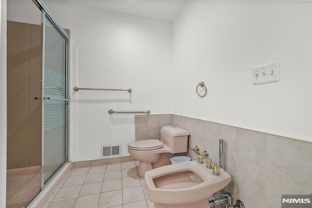 full bathroom with visible vents, a stall shower, tile walls, toilet, and tile patterned floors