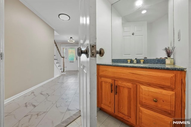 bathroom with baseboards, marble finish floor, and vanity