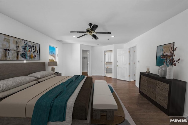 bedroom with wood finished floors, baseboards, recessed lighting, ceiling fan, and a walk in closet