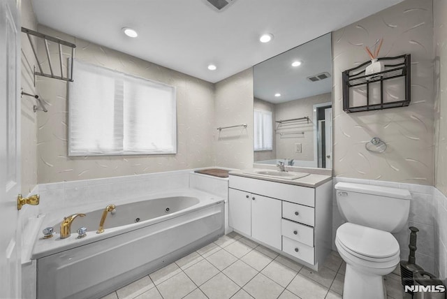 bathroom with toilet, recessed lighting, tile patterned floors, a tub with jets, and vanity