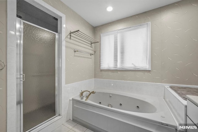 bathroom featuring tile patterned floors, a jetted tub, and a stall shower