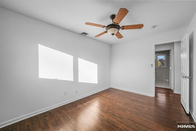 empty room featuring visible vents, ceiling fan, baseboards, and wood finished floors