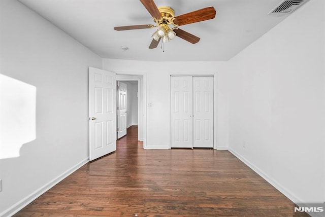 unfurnished bedroom featuring a ceiling fan, wood finished floors, visible vents, baseboards, and a closet