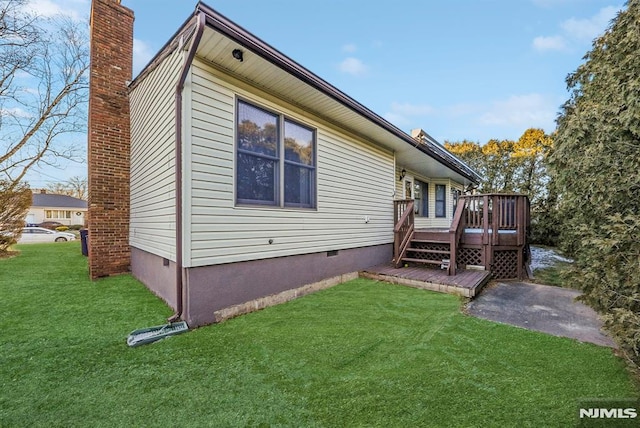 back of property featuring a deck, a yard, a chimney, and crawl space