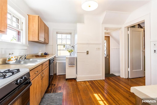 kitchen with dark wood-type flooring, light countertops, dishwashing machine, decorative backsplash, and a sink