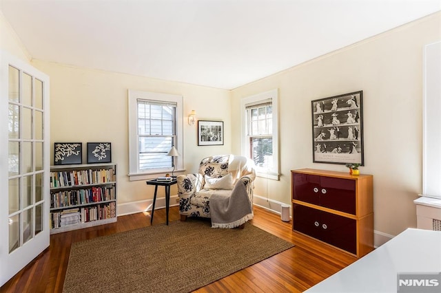 sitting room with baseboards and wood finished floors