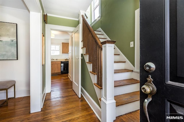 interior space featuring dark wood finished floors, stairway, crown molding, and baseboards