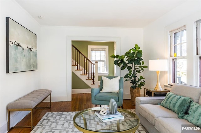 sitting room featuring stairway, baseboards, a healthy amount of sunlight, and wood finished floors