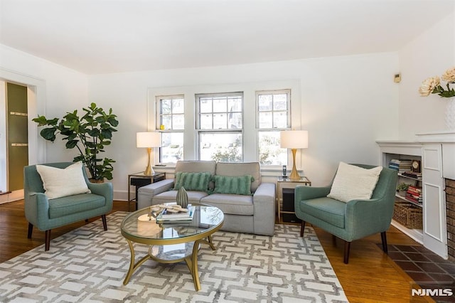 living area featuring a fireplace with flush hearth and wood finished floors