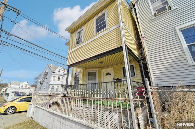 view of front of house with covered porch and a fenced front yard