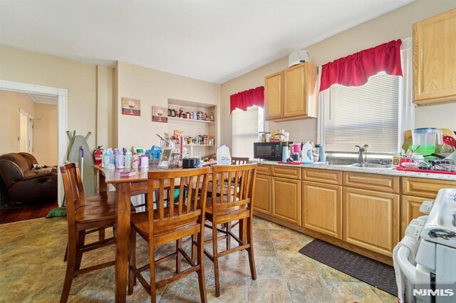 kitchen with black microwave, light countertops, gas range gas stove, and a sink