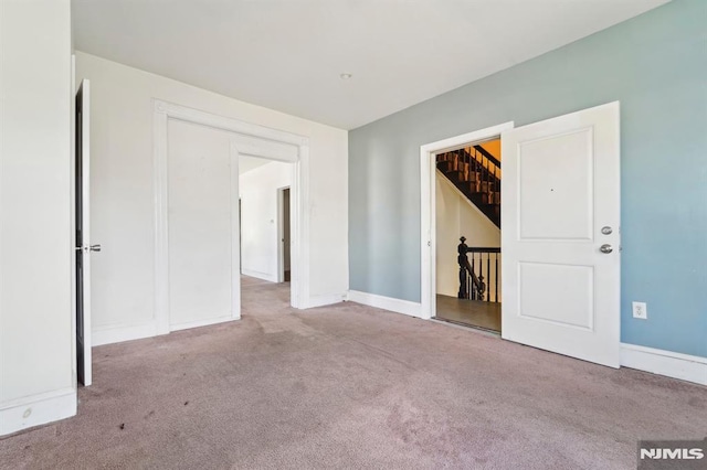 unfurnished room featuring carpet and baseboards