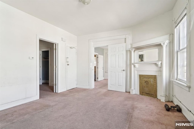 unfurnished living room featuring carpet floors and a fireplace