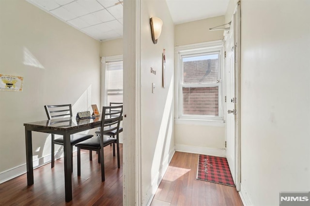 dining area with plenty of natural light, wood finished floors, and baseboards