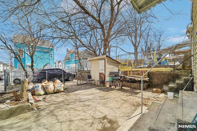 view of patio / terrace featuring a storage unit, an outbuilding, and a fenced backyard