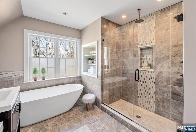 full bathroom featuring a freestanding bath, tile walls, a stall shower, and vanity