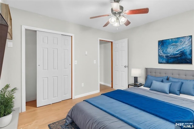 bedroom with a closet, a ceiling fan, light wood-type flooring, and baseboards