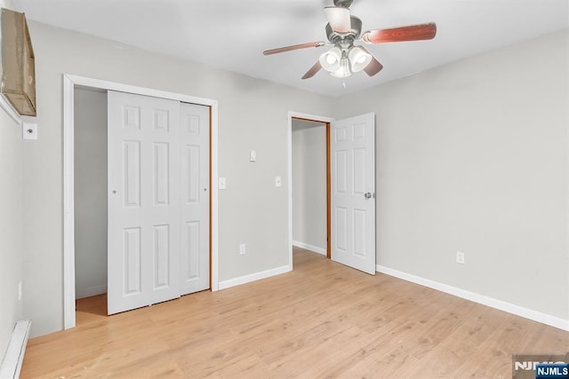 unfurnished bedroom with baseboards, baseboard heating, light wood-style flooring, a closet, and a ceiling fan