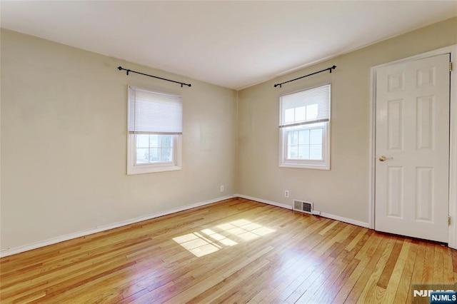 spare room featuring visible vents, baseboards, and light wood-style flooring