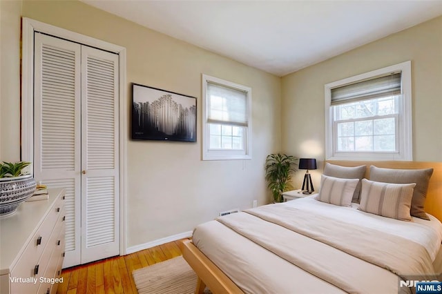 bedroom with a closet, baseboards, and light wood-style flooring