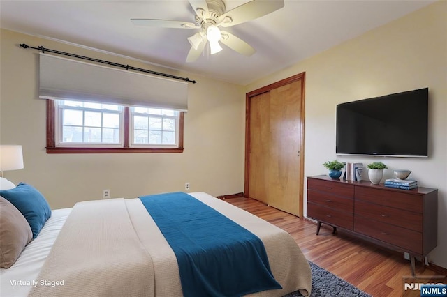 bedroom featuring light wood-style floors, a closet, and ceiling fan