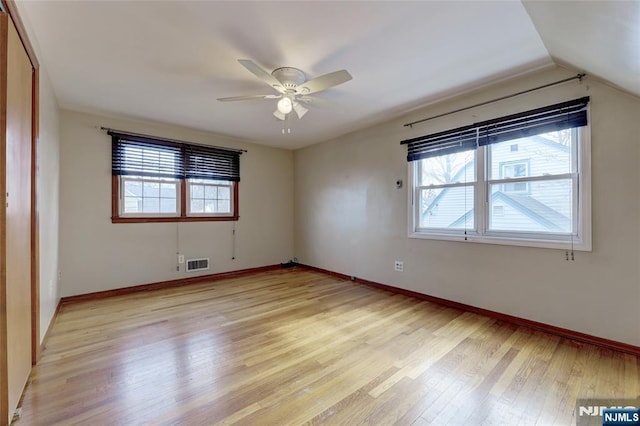 unfurnished room with visible vents, a healthy amount of sunlight, baseboards, and light wood-style floors