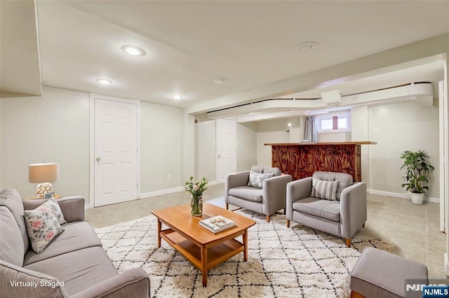 living room with light tile patterned floors, baseboards, a bar, and recessed lighting