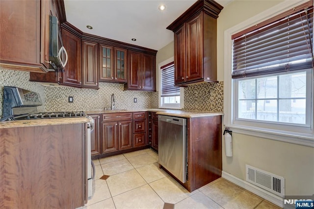 kitchen with visible vents, backsplash, light tile patterned floors, appliances with stainless steel finishes, and a sink