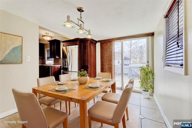 dining area with light tile patterned flooring and baseboards