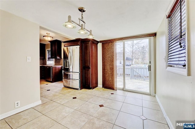 interior space with baseboards and light tile patterned flooring