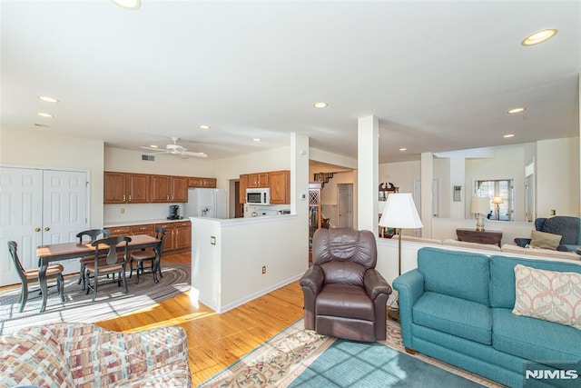 living area featuring recessed lighting, visible vents, light wood-style floors, and a ceiling fan