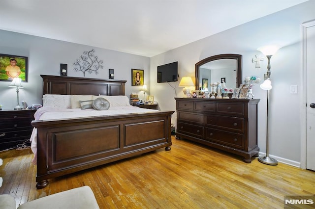 bedroom with light wood-type flooring and baseboards