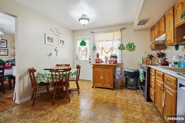 kitchen with visible vents, stainless steel appliances, light countertops, under cabinet range hood, and backsplash