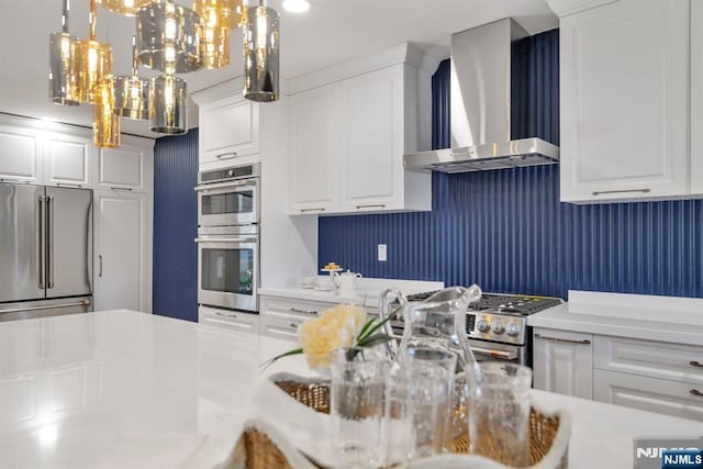 kitchen featuring white cabinets, wall chimney exhaust hood, and appliances with stainless steel finishes