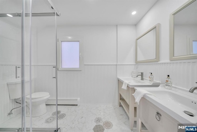 bathroom featuring a shower stall, wainscoting, a baseboard heating unit, toilet, and marble finish floor