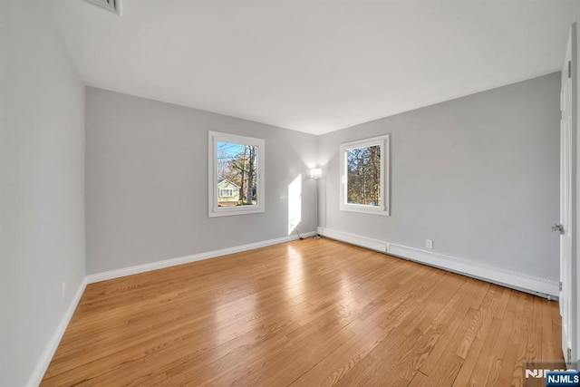 interior space with light wood-type flooring, baseboards, and a baseboard radiator