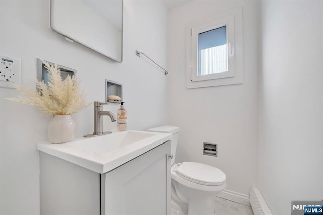 bathroom with a baseboard radiator, toilet, marble finish floor, and vanity