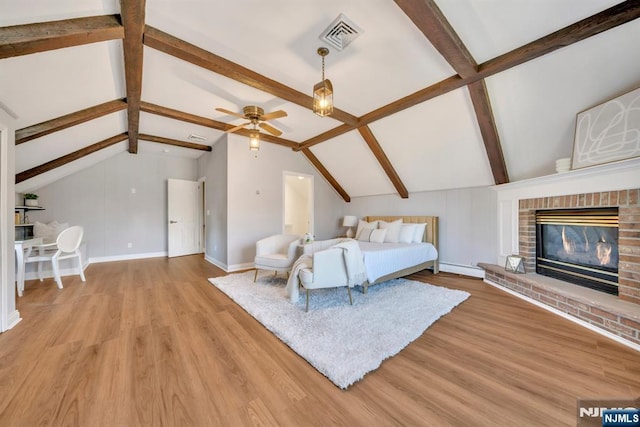 unfurnished bedroom with light wood-type flooring, visible vents, lofted ceiling with beams, and a fireplace