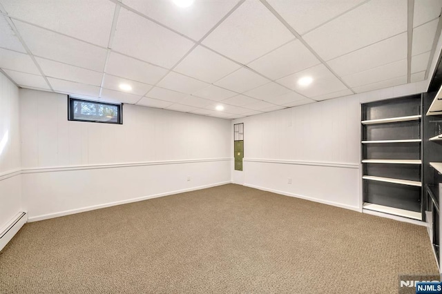 basement featuring baseboards, a paneled ceiling, baseboard heating, and carpet flooring