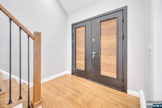 foyer with french doors, baseboards, wood finished floors, and stairs