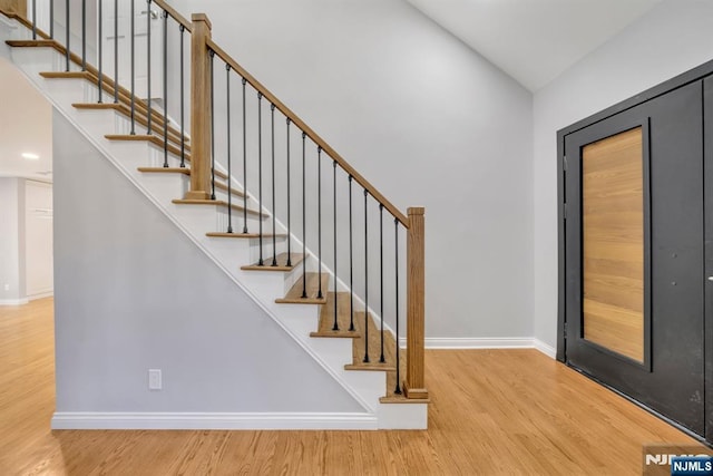 staircase with baseboards and wood finished floors