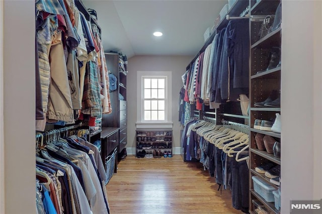 spacious closet with wood finished floors and vaulted ceiling