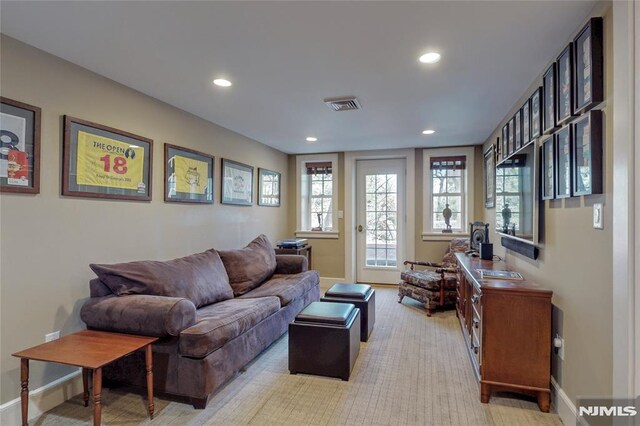 living area with recessed lighting, visible vents, and baseboards