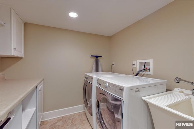 clothes washing area with baseboards, recessed lighting, washer and dryer, cabinet space, and a sink