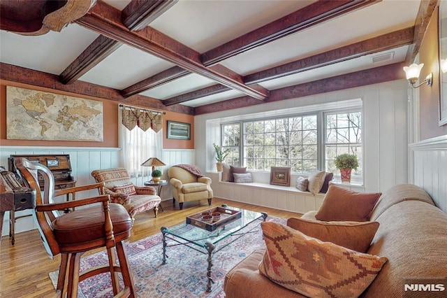 interior space with visible vents, beam ceiling, wood finished floors, and a decorative wall